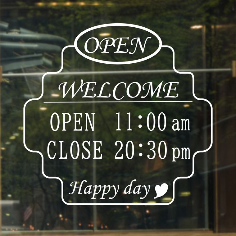 夜の店舗ガラスに貼られた装飾的な営業時間サインの施工例